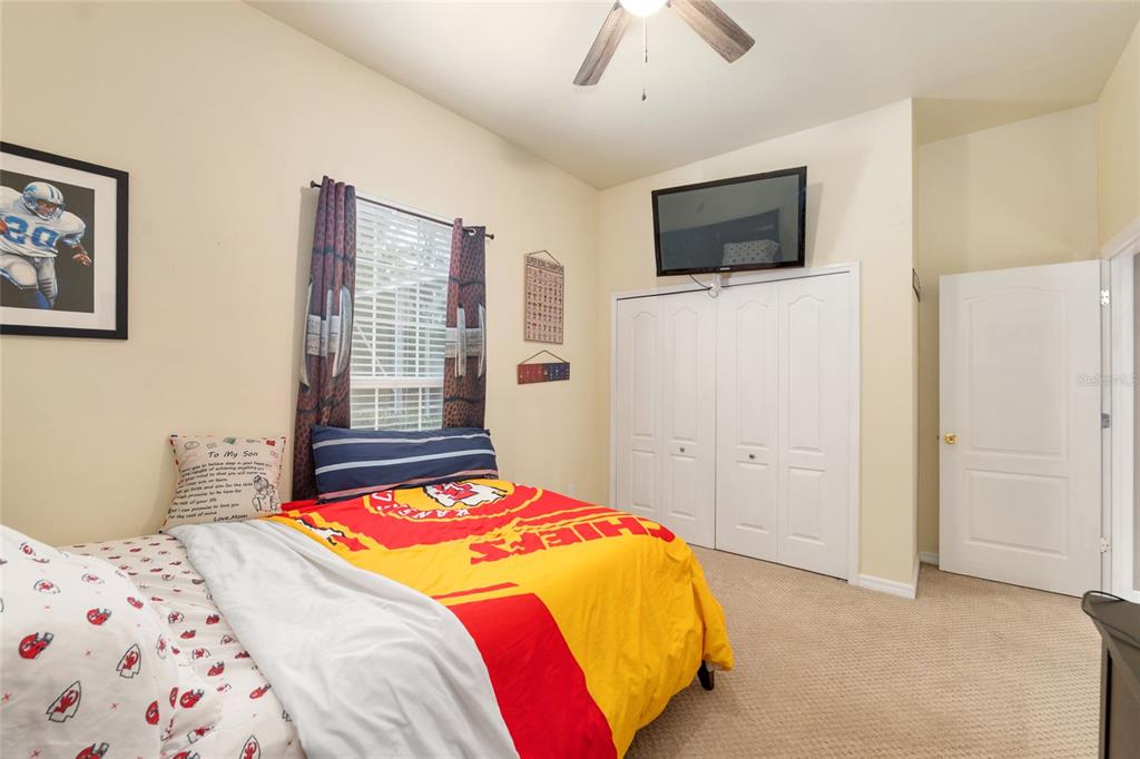 9350 Southwest 46 Place Gainesville, FL 32608 - Photo 46 of 63 a bedroom with a bed and a flat tv screen on dresser