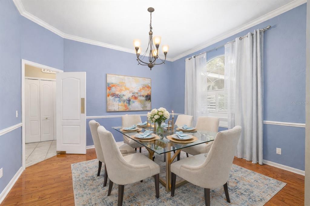9350 Southwest 46 Place Gainesville, FL 32608 - Photo 10 of 63 a dining room with furniture a chandelier and wooden floor