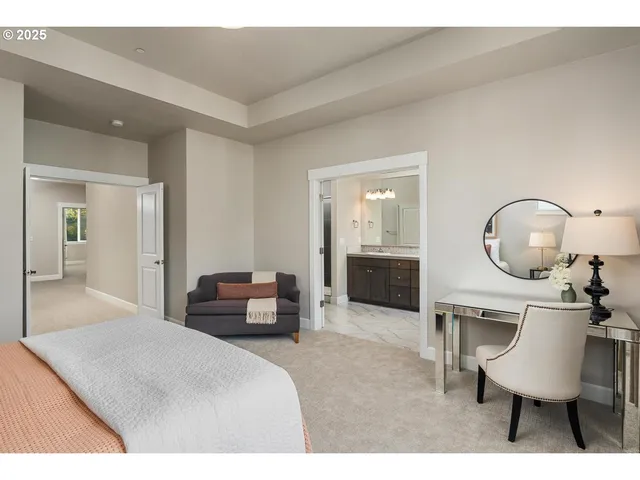 a bedroom with a bed a mirror on dresser and a table