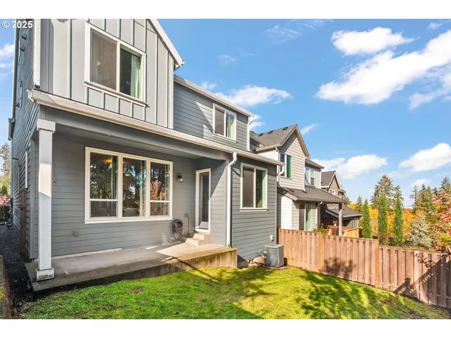 a view of a house with a small yard and wooden fence