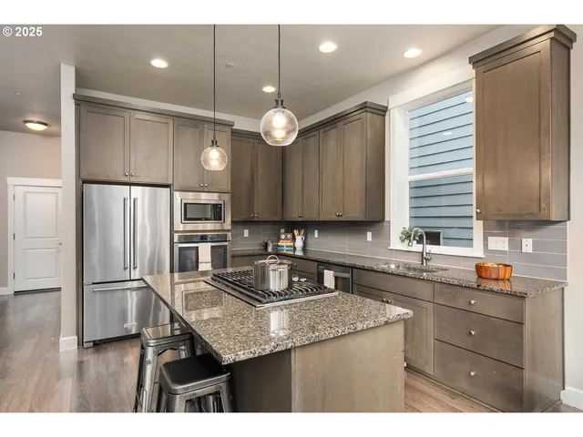 a kitchen with a sink stainless steel appliances and cabinets