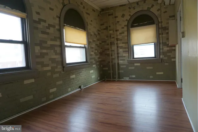 a view of a room has wooden floor and a window