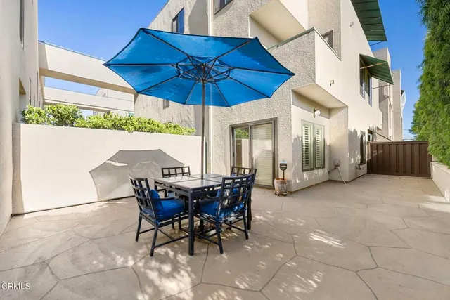 a view of a patio with table and chairs under an umbrella