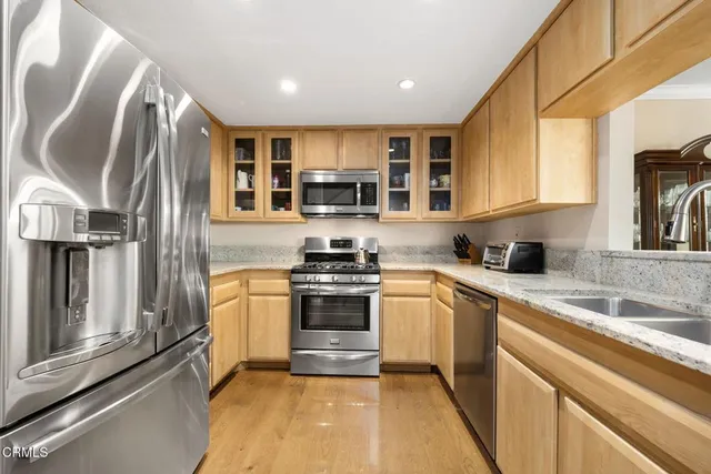 a kitchen with stainless steel appliances granite countertop a stove top oven a sink and a microwave