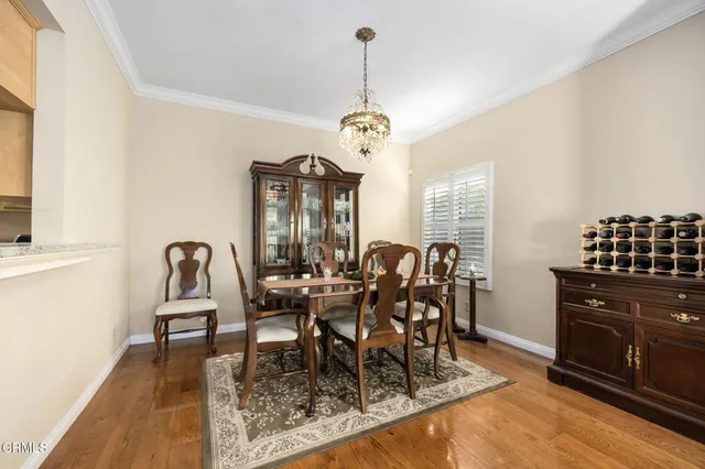 a dining room with furniture a chandelier and wooden floor