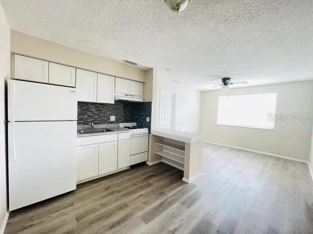 a kitchen with granite countertop white cabinets and white appliances