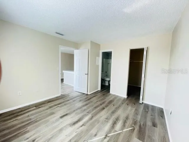 an empty room with wooden floor and closet