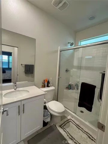 a bathroom with a sink a toilet a mirror and shower