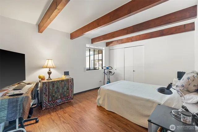 a bedroom with a bed and wooden floor