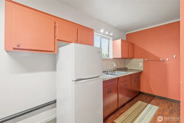 a white refrigerator freezer and a wooden floor