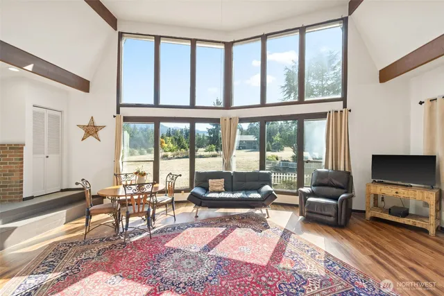 a living room with furniture a flat screen tv and a floor to ceiling window