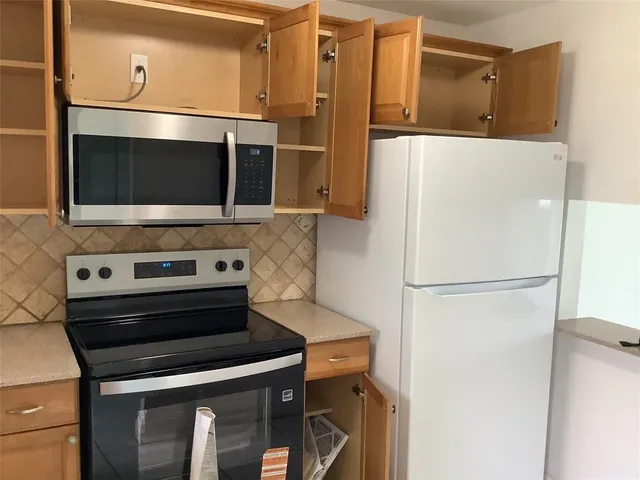 a kitchen with granite countertop a sink and a stove with wooden floor