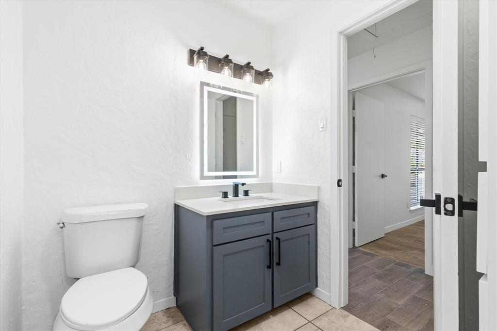 17003 Davenport Road Dallas, TX 75248 - Photo 36 of 40 a bathroom with a toilet a sink and mirror