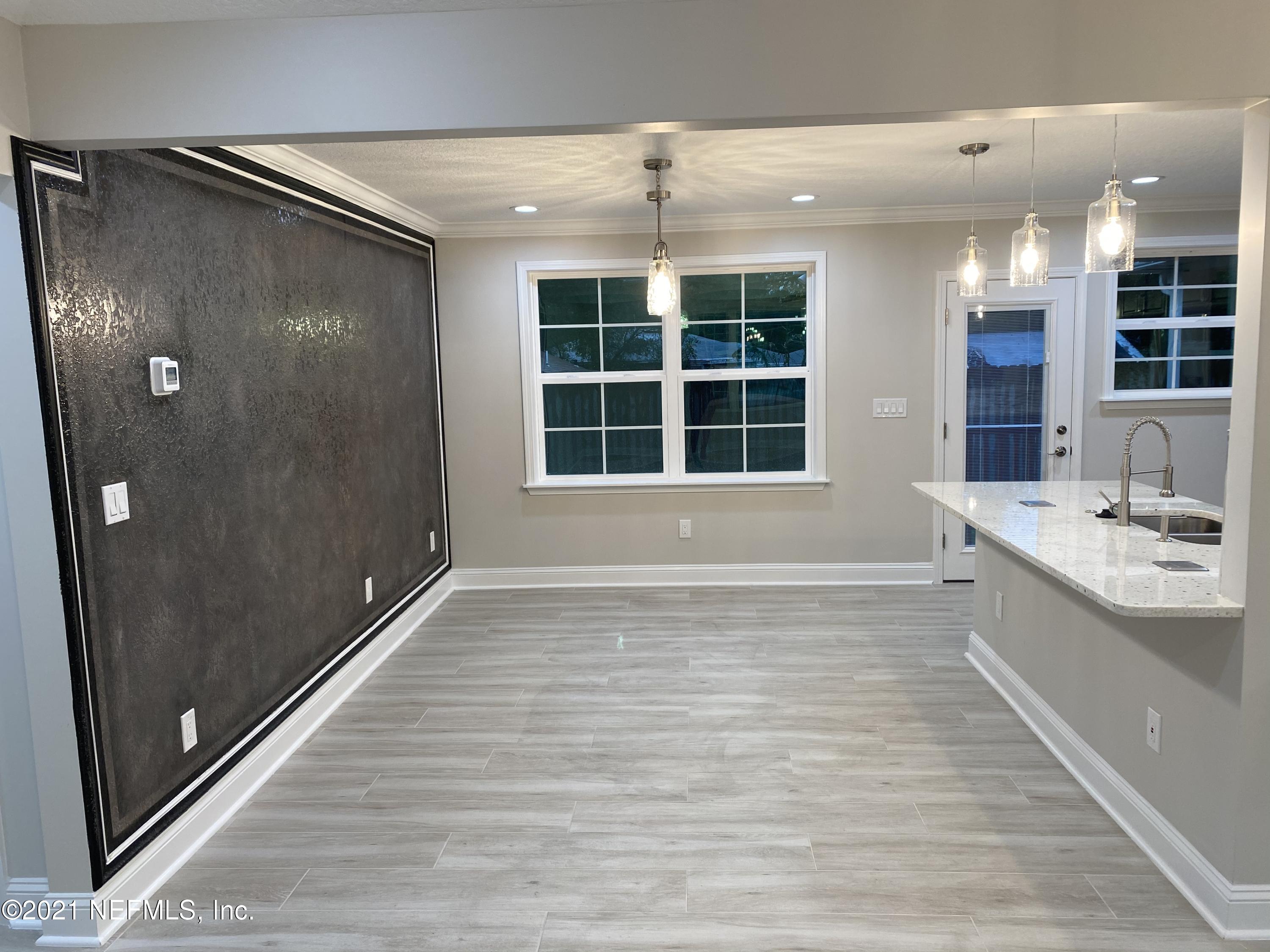9709 Lily Road Jacksonville, FL 32246 - Photo 17 of 60 a view of a hallway with wooden floor and a large window