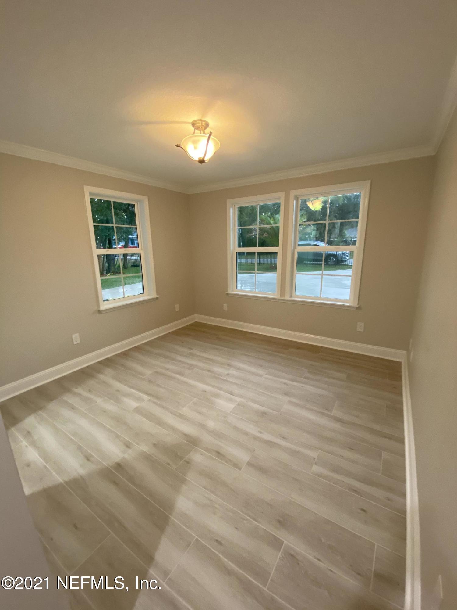 9709 Lily Road Jacksonville, FL 32246 - Photo 25 of 60 an empty room with wooden floor and windows