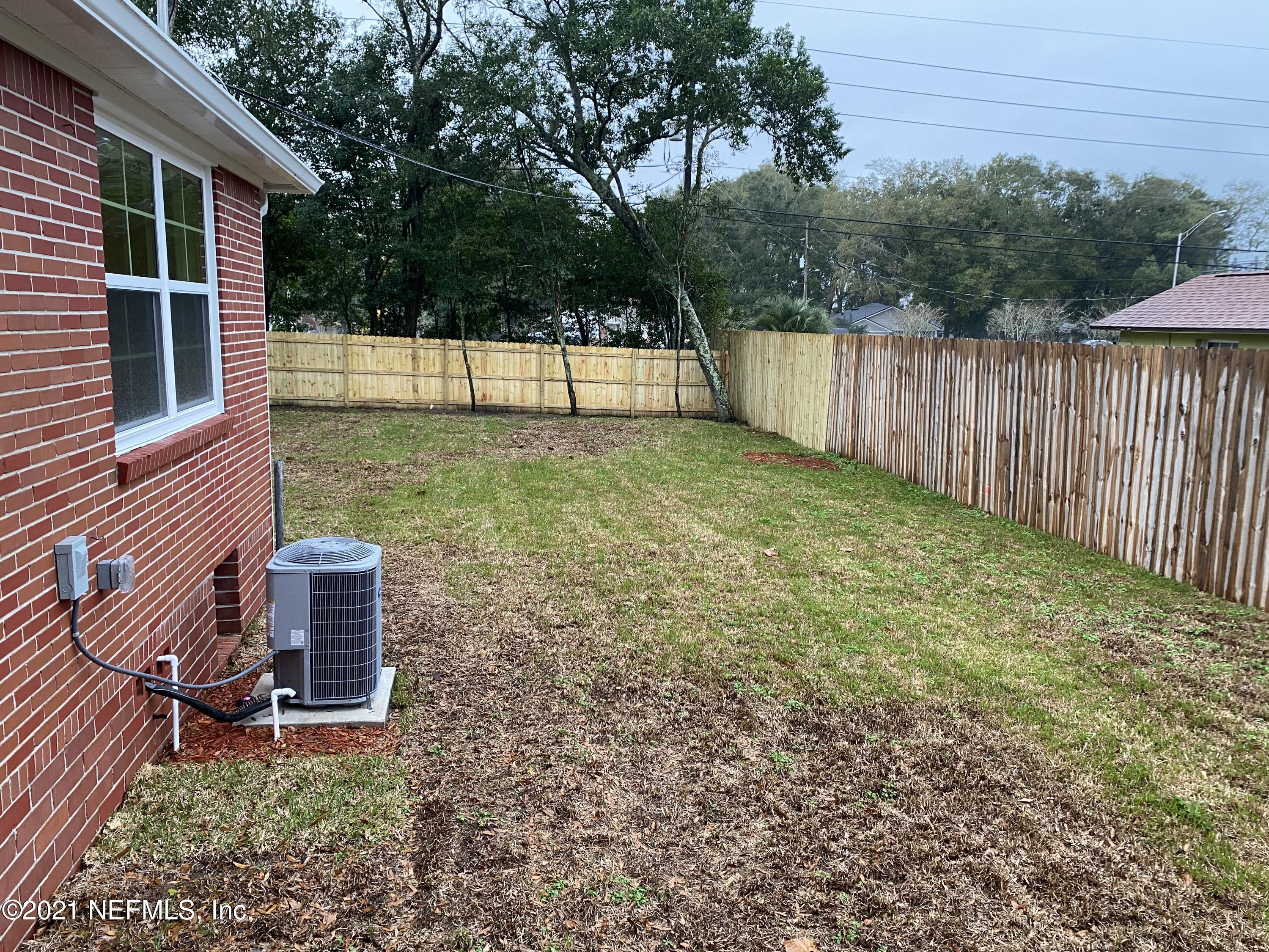9709 Lily Road Jacksonville, FL 32246 - Photo 50 of 60 a view of a backyard with large trees and wooden fence