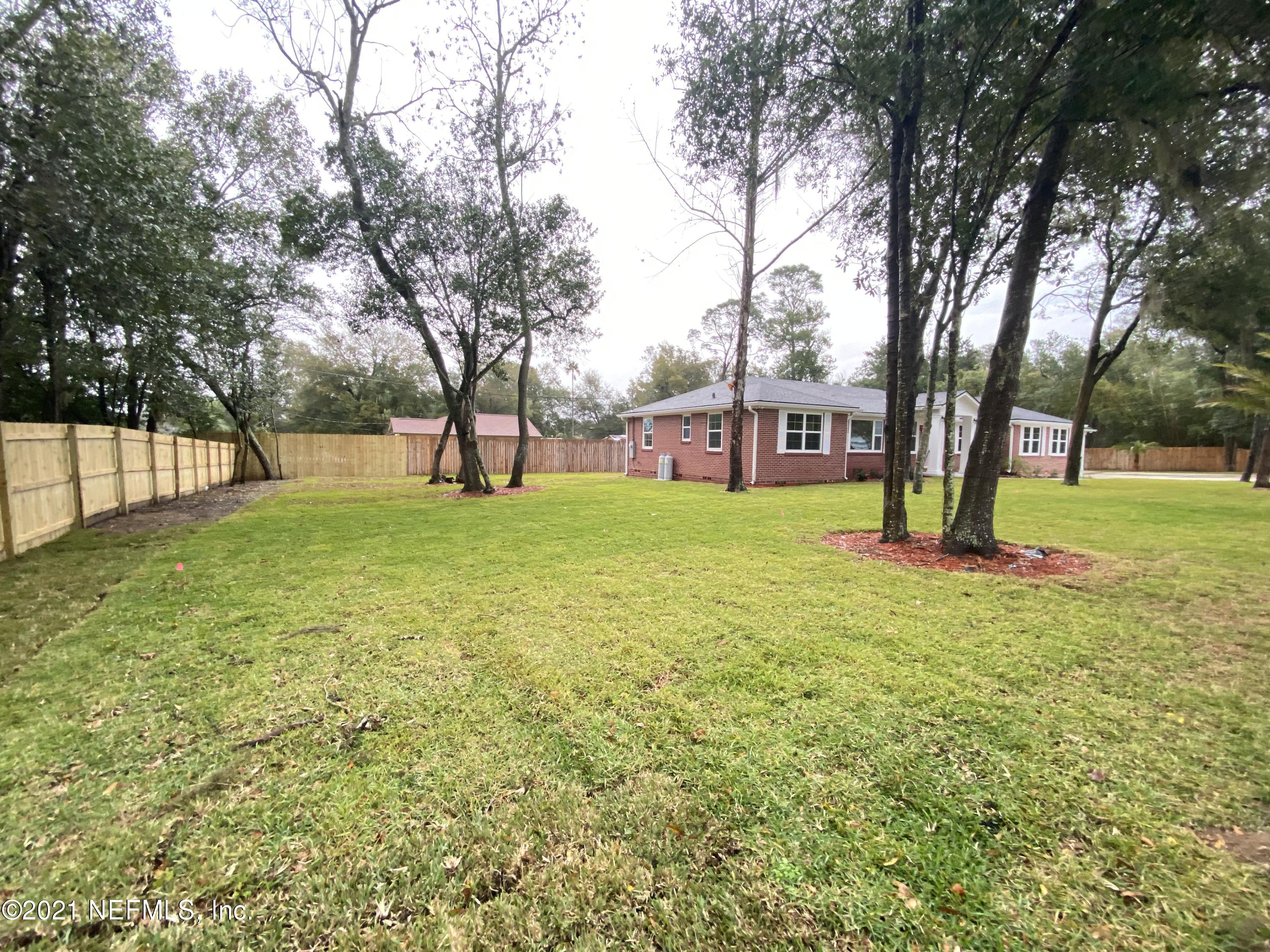 9709 Lily Road Jacksonville, FL 32246 - Photo 55 of 60 a view of a house with a big yard and large trees
