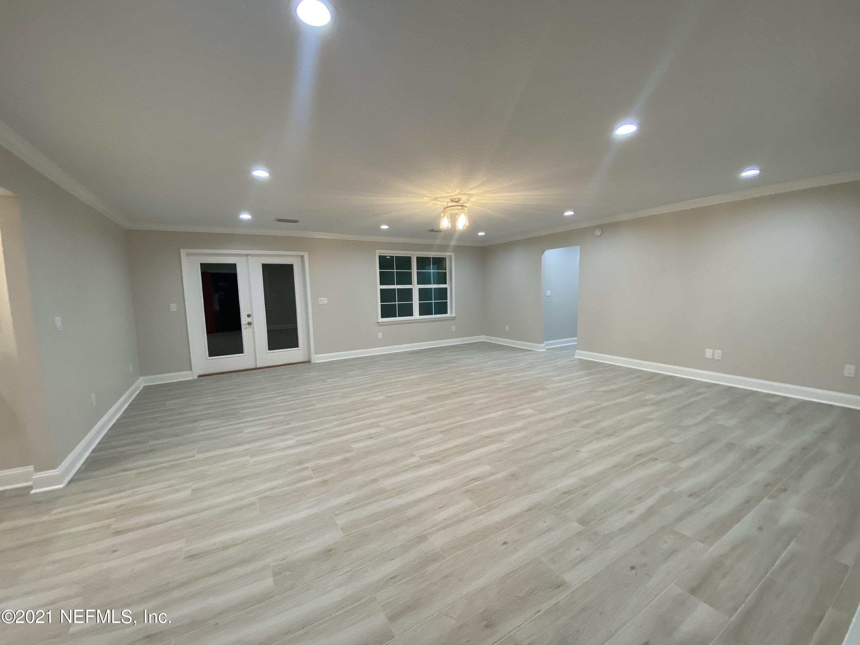 9709 Lily Road Jacksonville, FL 32246 - Photo 6 of 60 an empty room with wooden floor and windows
