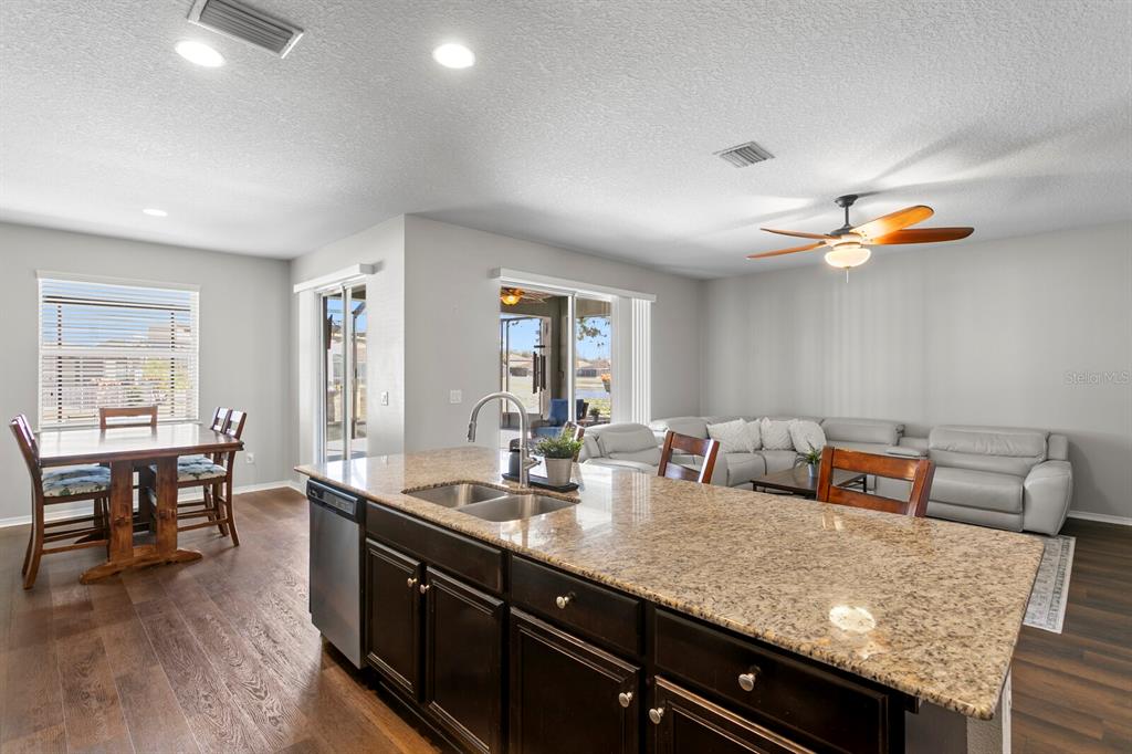 2839 Maple Brook Loop Lutz, FL 33558 - Photo 13 of 61 a kitchen with granite countertop a dining table chairs sink and granite counter tops