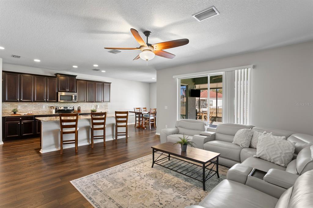 2839 Maple Brook Loop Lutz, FL 33558 - Photo 15 of 61 a living room with furniture wooden floor and kitchen view