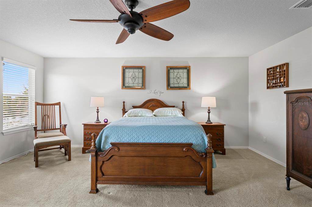 2839 Maple Brook Loop Lutz, FL 33558 - Photo 28 of 61 a bedroom with a bed and a chandelier
