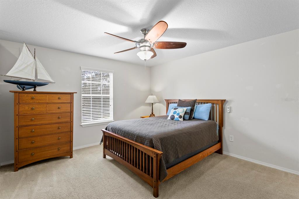 2839 Maple Brook Loop Lutz, FL 33558 - Photo 33 of 61 a bedroom with a bed and a ceiling fan
