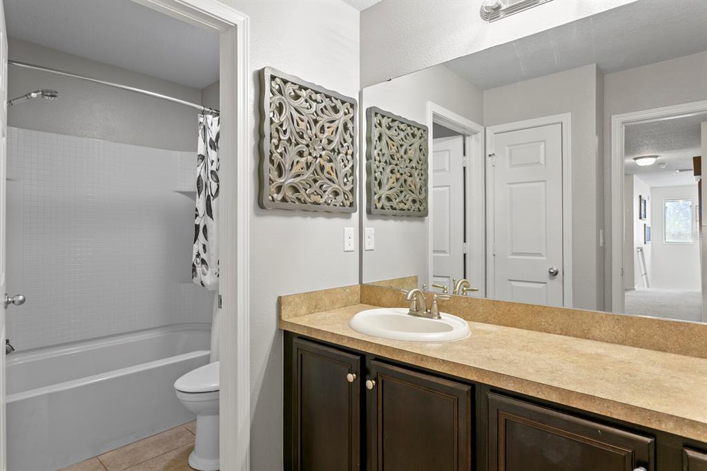 2839 Maple Brook Loop Lutz, FL 33558 - Photo 37 of 61 a bathroom with a granite countertop sink toilet and shower