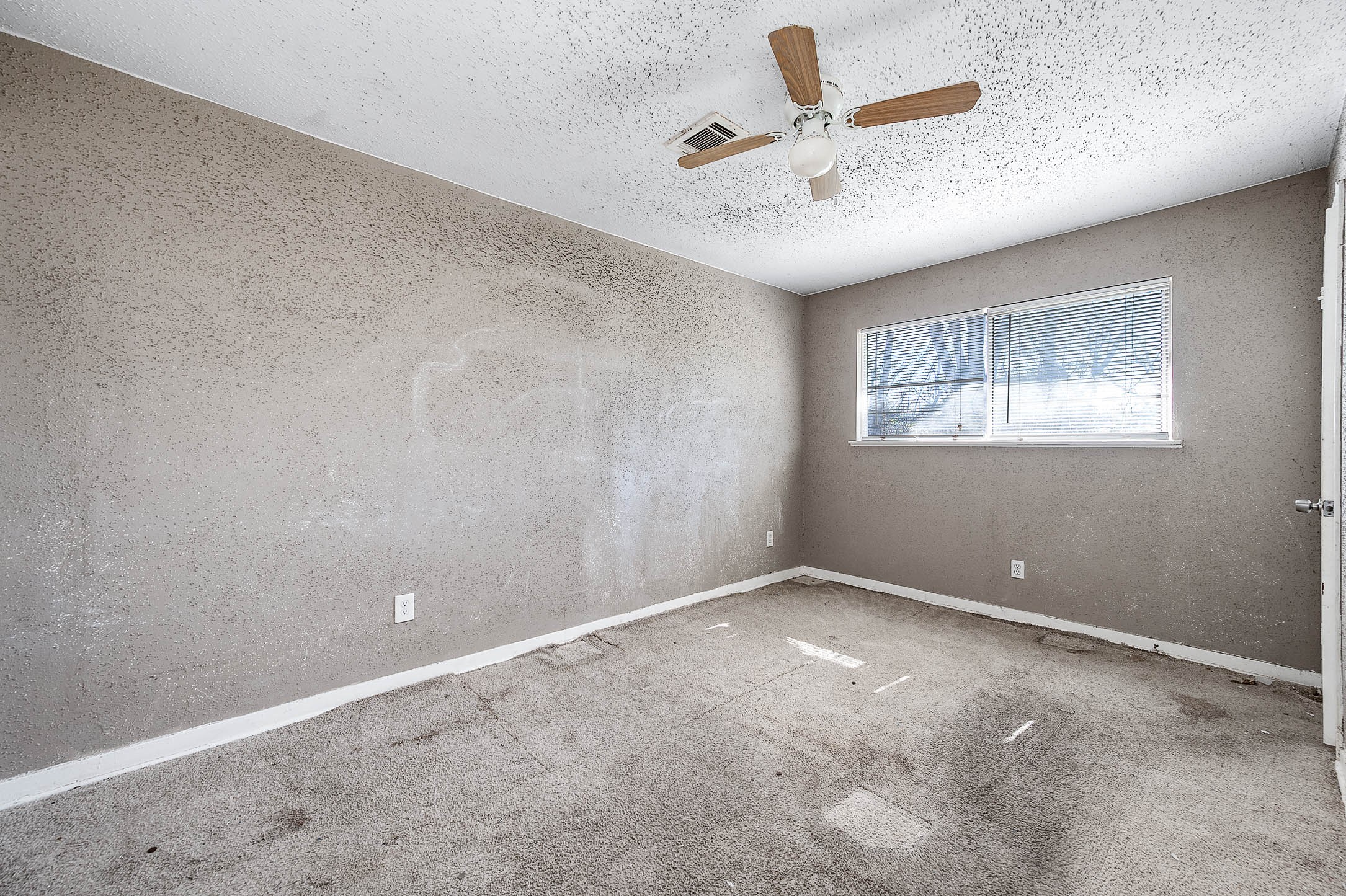 6110 Guadalupe Street Houston, TX 77016 - Photo 15 of 24 an empty room with a window and a fan