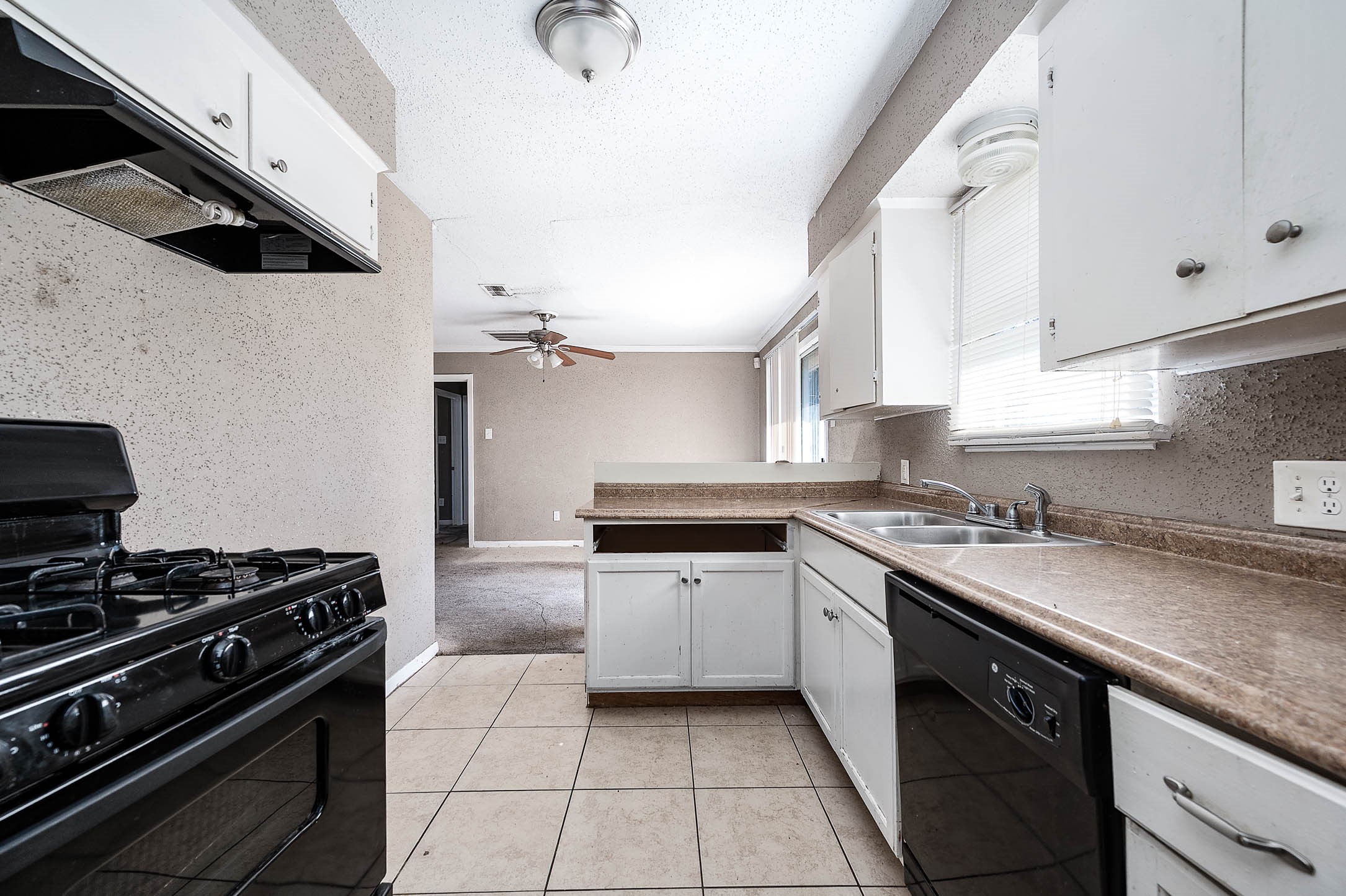 6110 Guadalupe Street Houston, TX 77016 - Photo 9 of 24 a kitchen with a sink a stove and cabinets