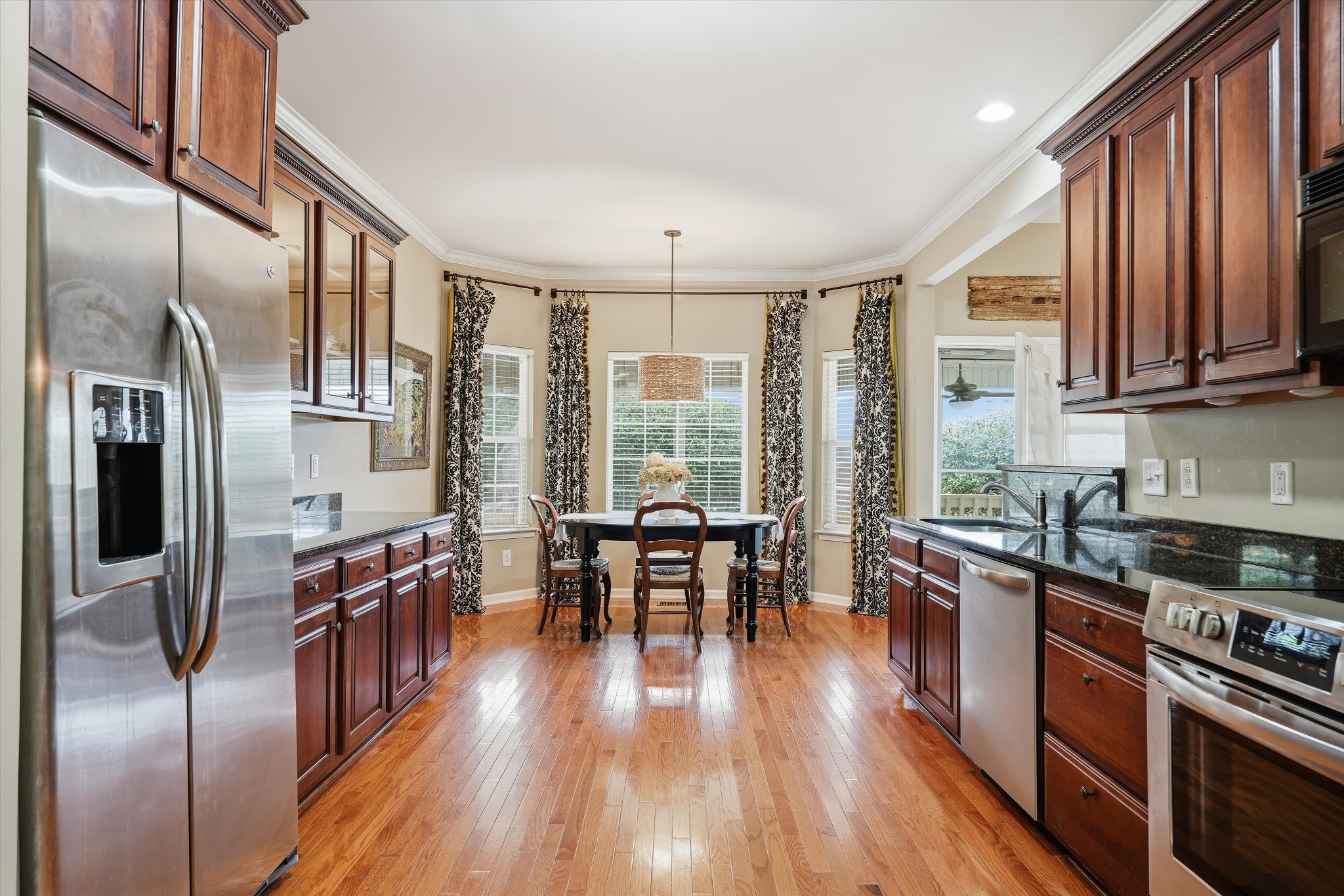 132 Windchase Run Hermitage, TN 37076 - Photo 14 of 38 a kitchen with stainless steel appliances granite countertop a stove top oven a refrigerator a dining table and chairs with wooden floor
