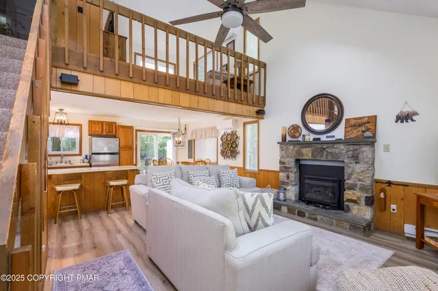 a living room with furniture a fireplace and a floor to ceiling window