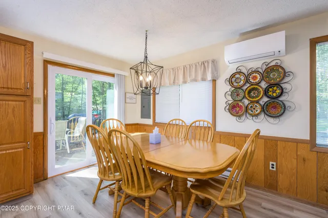 a dining room with furniture a chandelier and wooden floor