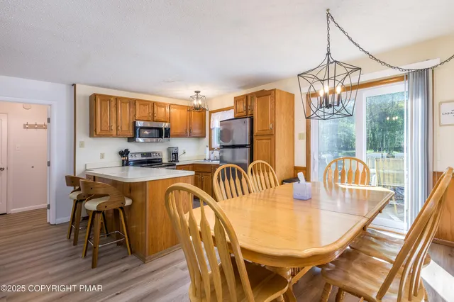 a dining room with furniture a chandelier and wooden floor