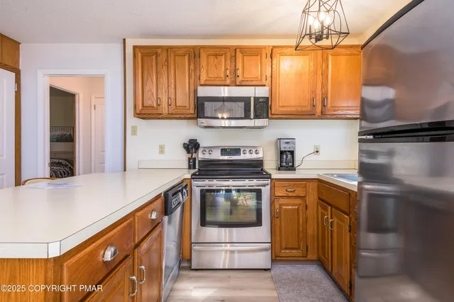 a kitchen with stainless steel appliances a stove a sink and a refrigerator