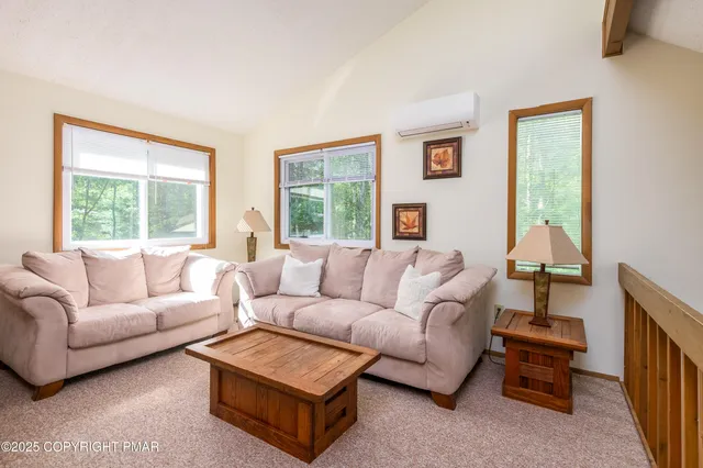 a living room with furniture a flat screen tv and a window