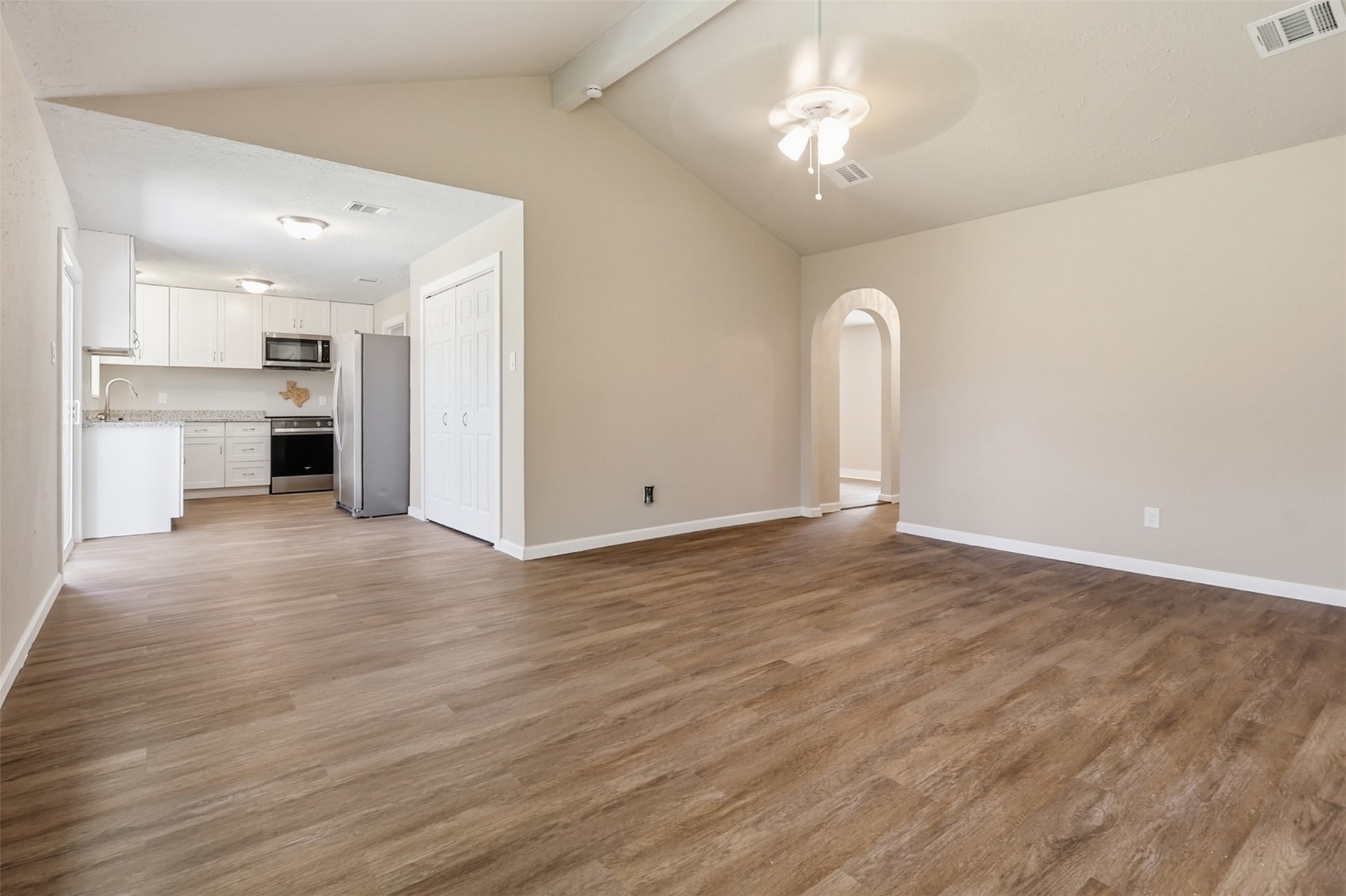 4767 Beechaven Street Houston, TX 77053 - Photo 18 of 26 a view of empty room with wooden floor and kitchen view
