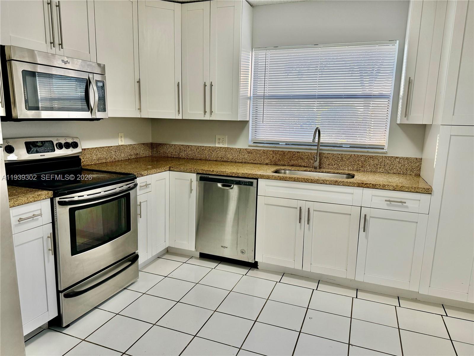 3370 Beau Rivage Drive, Unit 1R Pompano Beach, FL 33064 - Photo 1 of 15 a kitchen with cabinets appliances and a sink