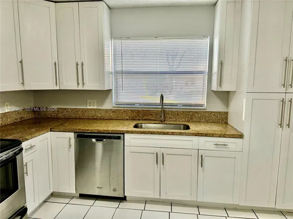 a kitchen with cabinets appliances and a sink