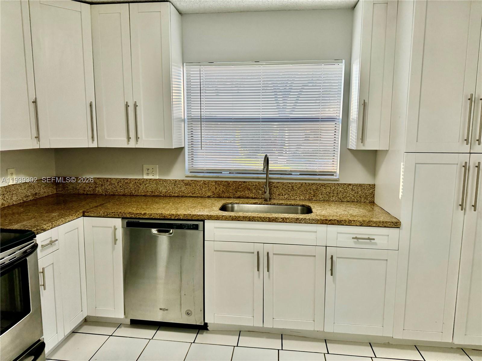 3370 Beau Rivage Drive, Unit 1R Pompano Beach, FL 33064 - Photo 3 of 15 a kitchen with cabinets appliances and a sink