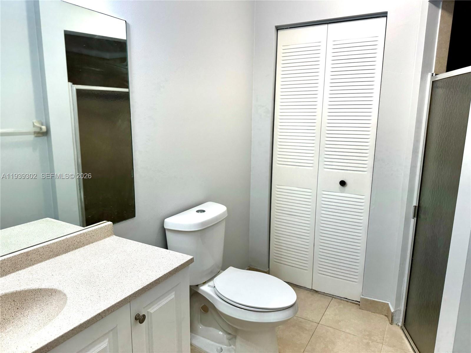 3370 Beau Rivage Drive, Unit 1R Pompano Beach, FL 33064 - Photo 7 of 15 a bathroom with a sink a toilet and shower