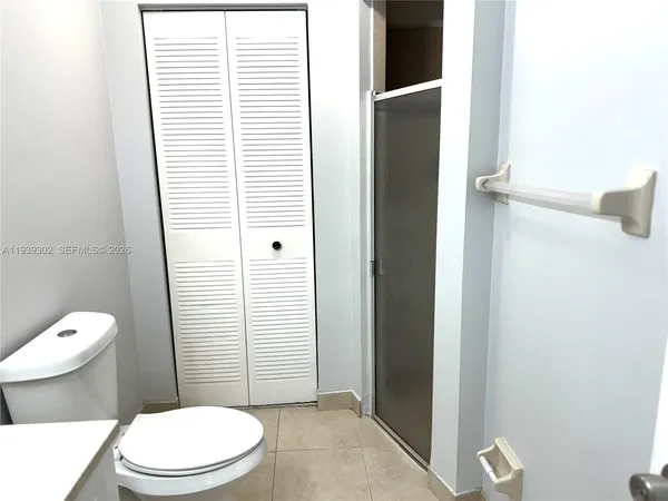 a white toilet sitting next to a bathroom sink and a window