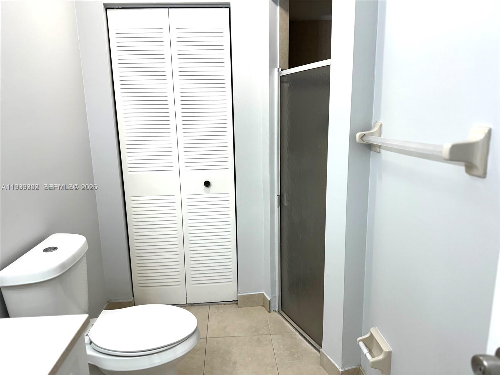 3370 Beau Rivage Drive, Unit 1R Pompano Beach, FL 33064 - Photo 8 of 15 a white toilet sitting next to a bathroom sink and a window