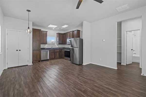 a kitchen with stainless steel appliances a refrigerator and wooden floor