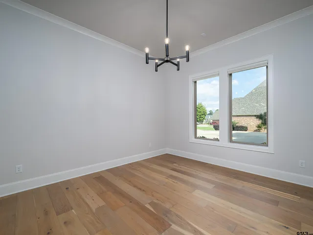 an empty room with a window and a ceiling fan