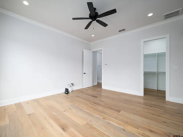 a view of room with wooden floor and ceiling fan