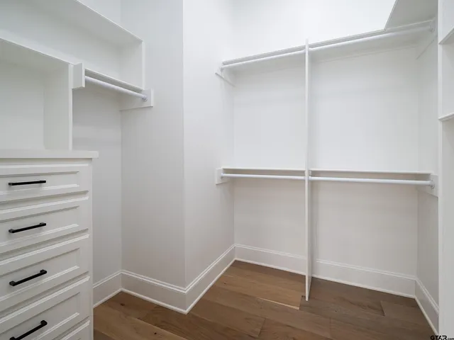 a view of walk in closet with empty racks