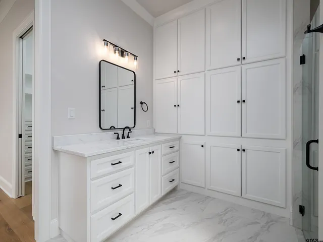 a bathroom with a granite countertop sink vanity and mirror