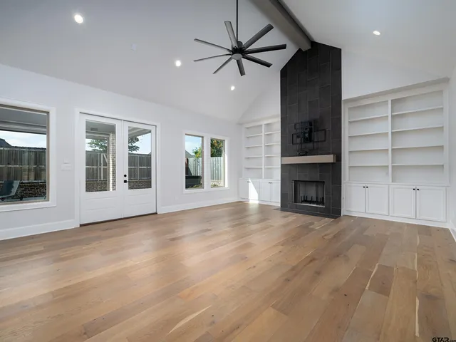 a view of an empty room with a fireplace and a window
