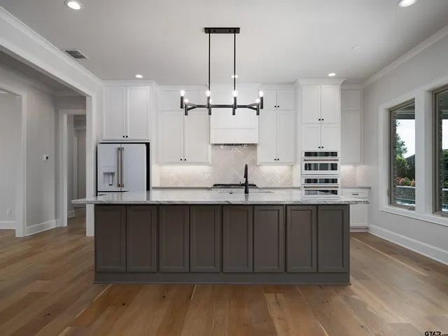 a kitchen with granite countertop a sink cabinets and wooden floor