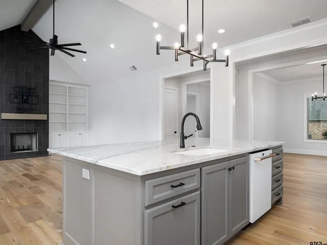 a kitchen with a sink dishwasher a stove and a refrigerator with wooden floor